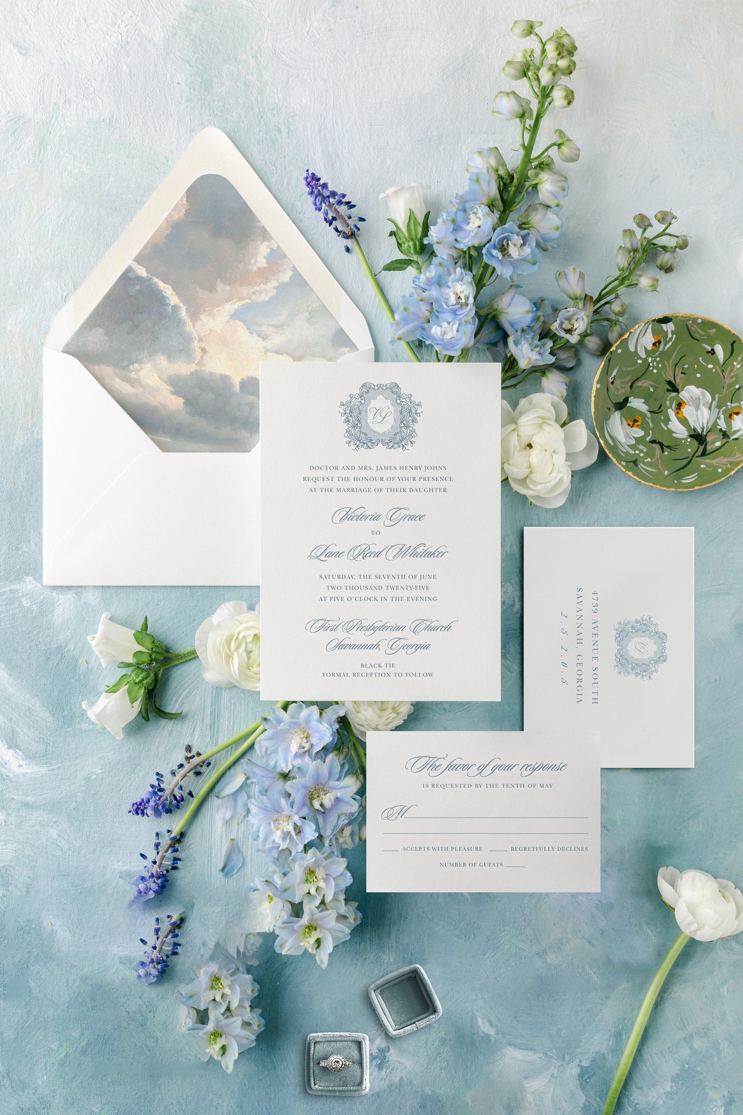 Wedding invitation set with flowers on a textured blue surface