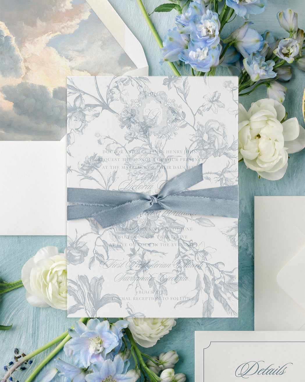 Decorative card with floral design and blue ribbon on a background of flowers and watercolor elements.