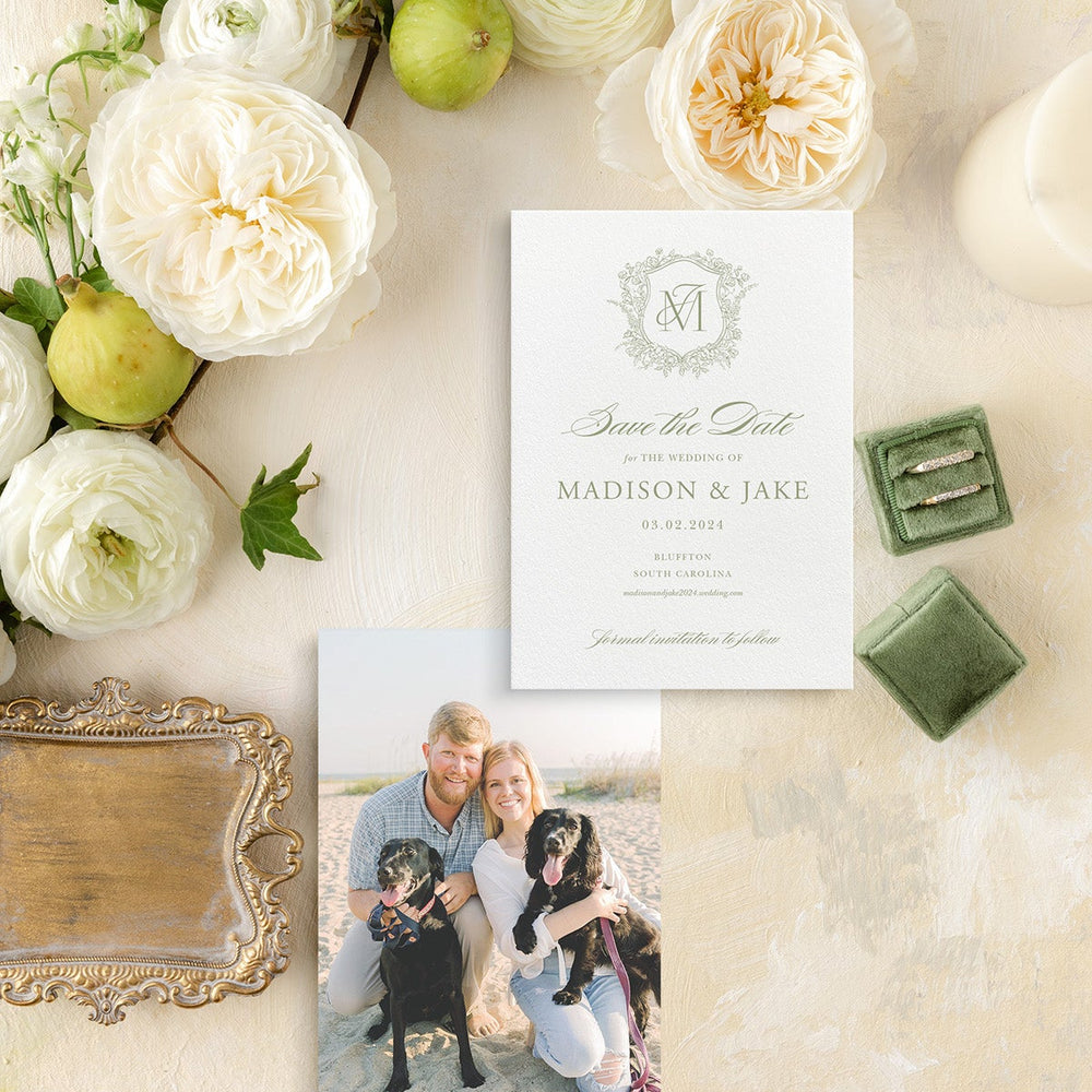 Wedding Save the Date with photo of couple and dogs, surrounded by fruits and flowers on a decorative surface.