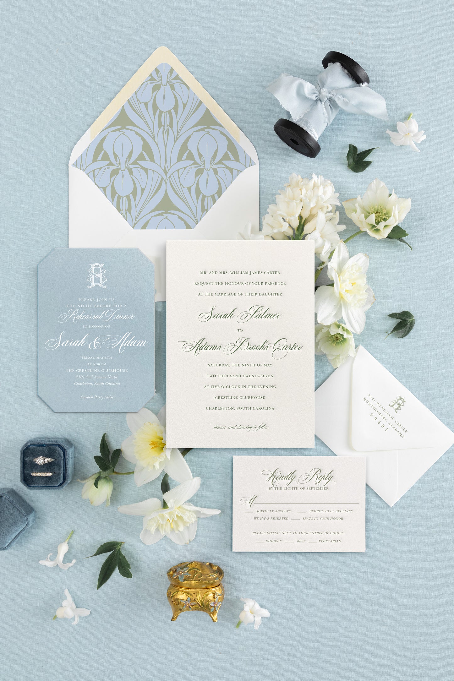 Wedding invitation set with floral elements on a light blue background