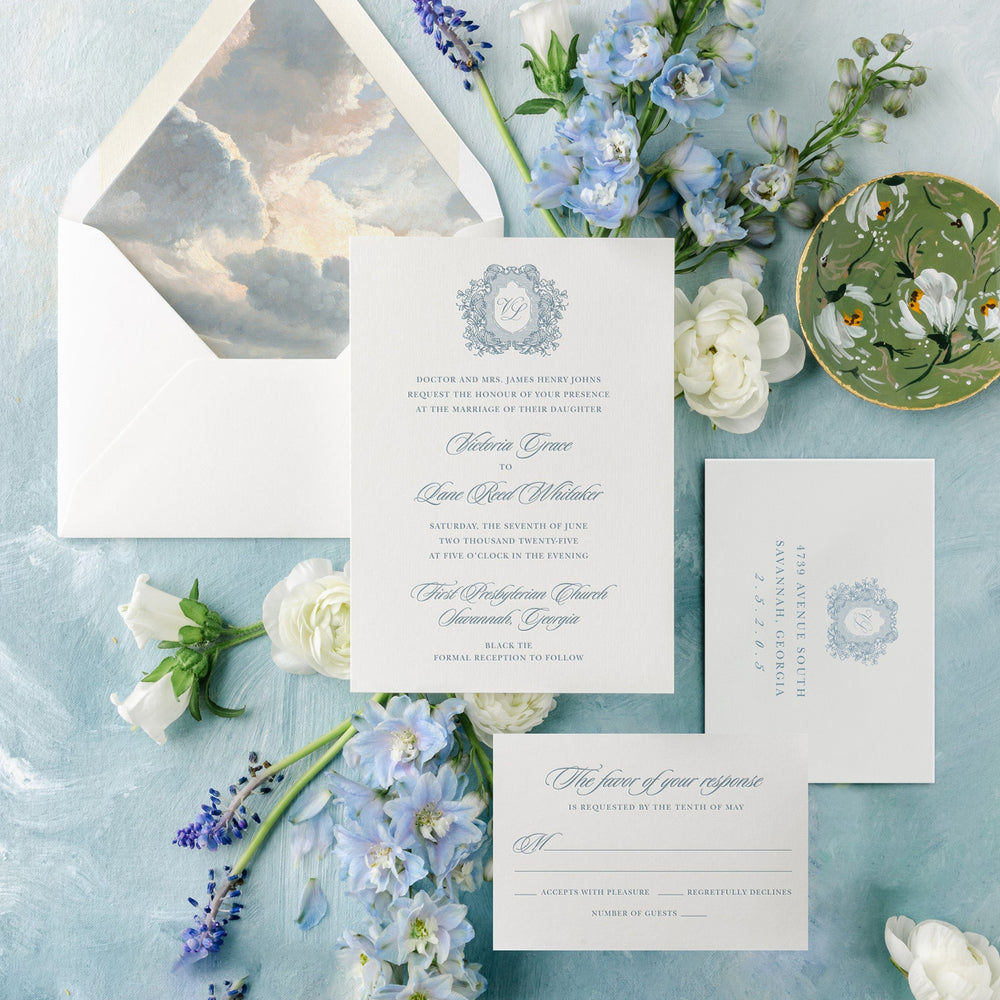Wedding invitation set with flowers on a textured blue surface